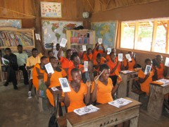 Students in Ghana holding up their e-readers